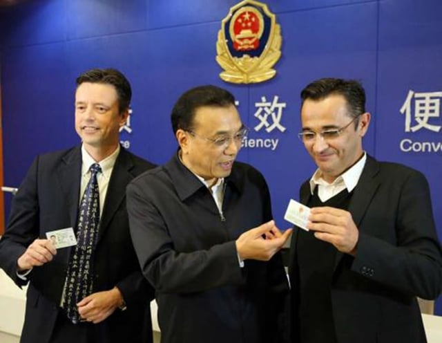 3 men holding two cards