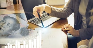 Two people discussing company accounts at a desk.