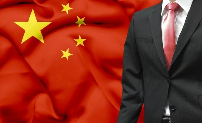 choosing a China wfoe legal representative business man in front of chinese flag