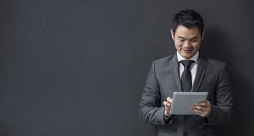 Man in a suit working on his iPad